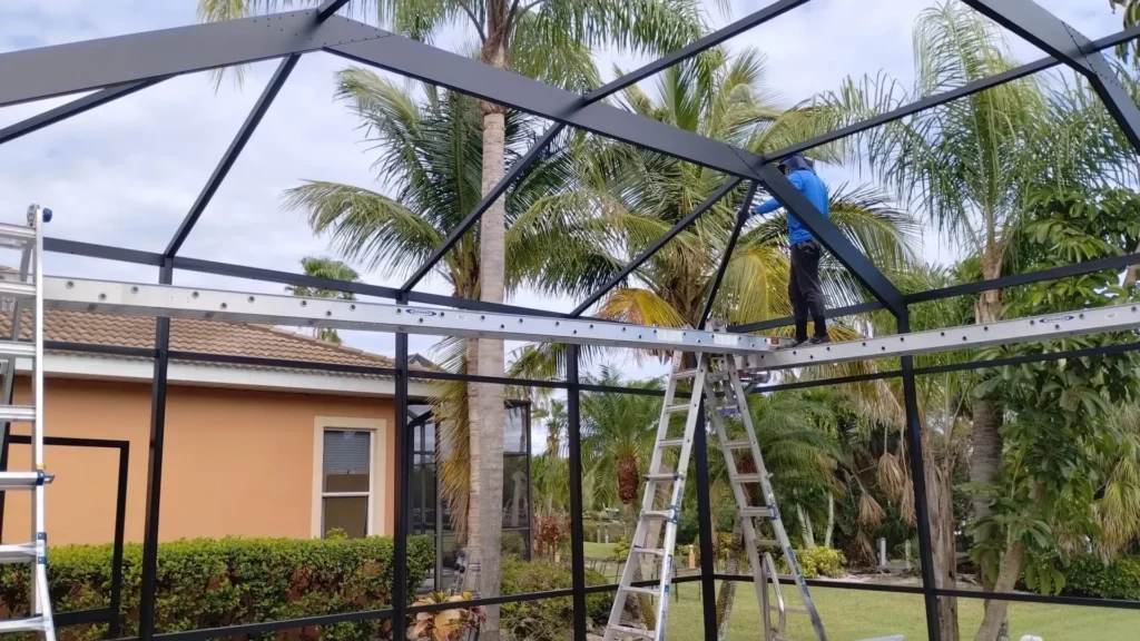 A Bronze Pool Cage just painted, and an ABC Pool Cage Painting worker is inspecting the job