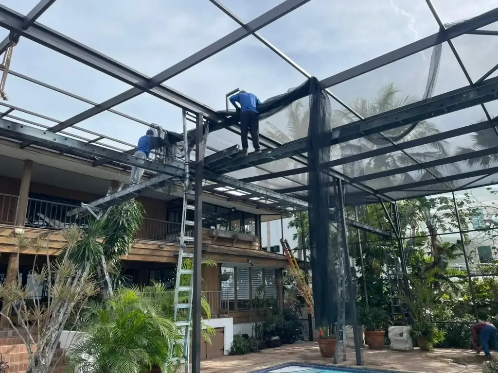 Workers repairing pool enclosure frame