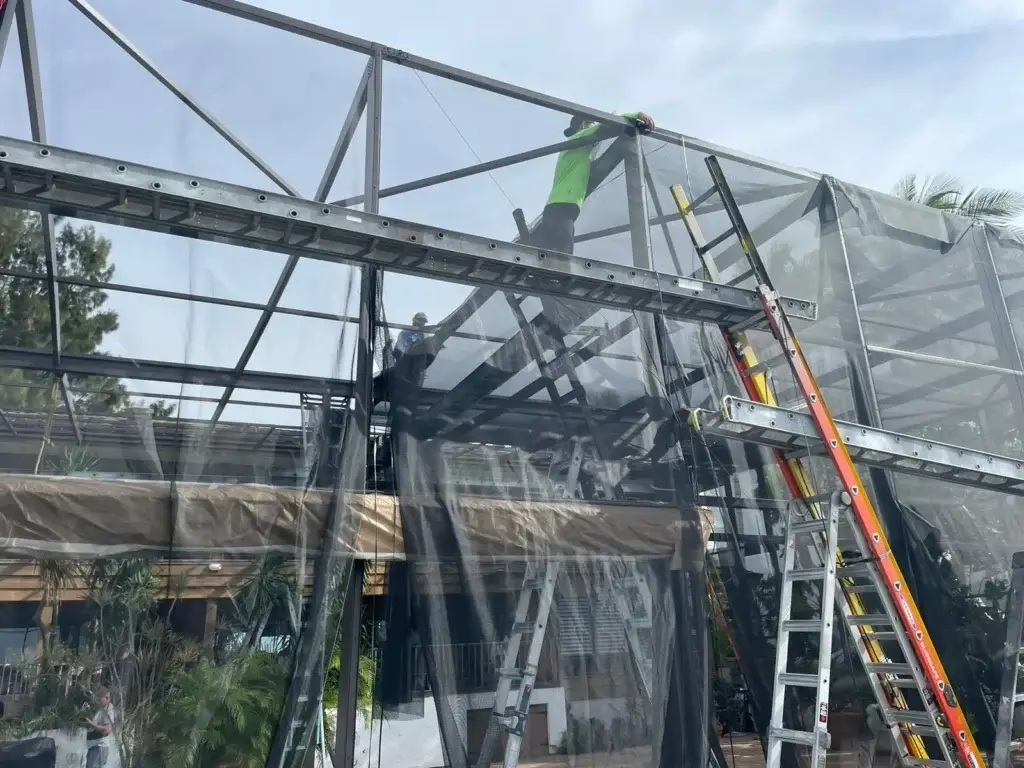 Construction workers on ladders with netting