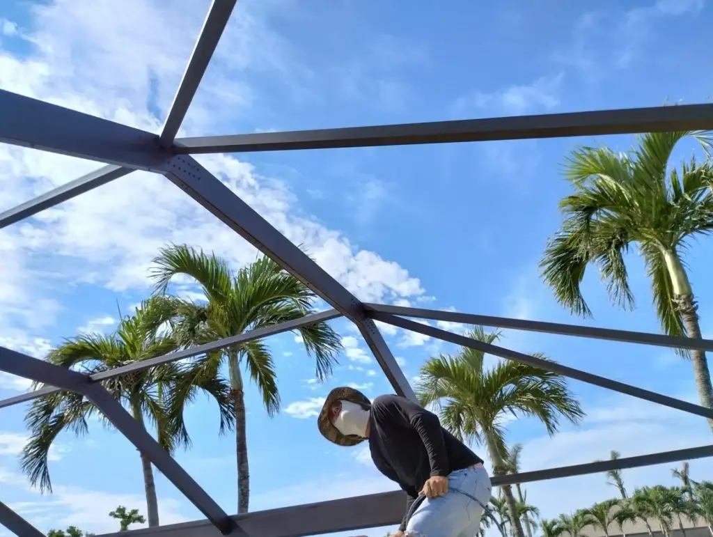 Person on working on a Pool Cage Painting and Pool Cage Rescreening in Tampa, FL