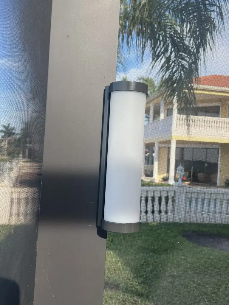 LED column light mounted on a pool cage post, close-up in daylight