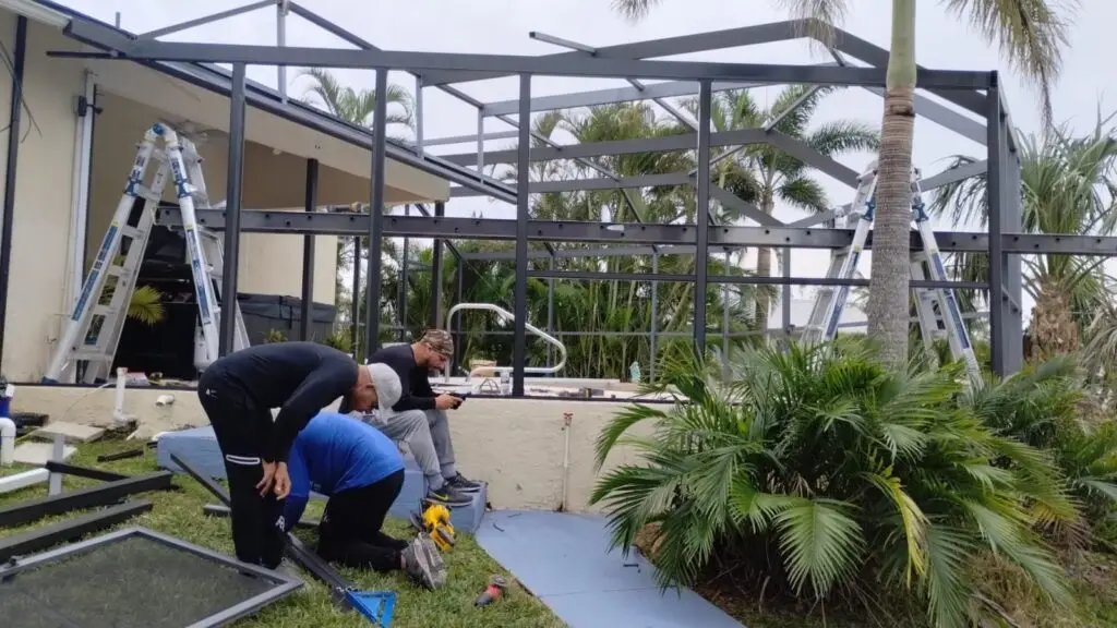 Crew repairing the aluminum frame of a pool cage before painting