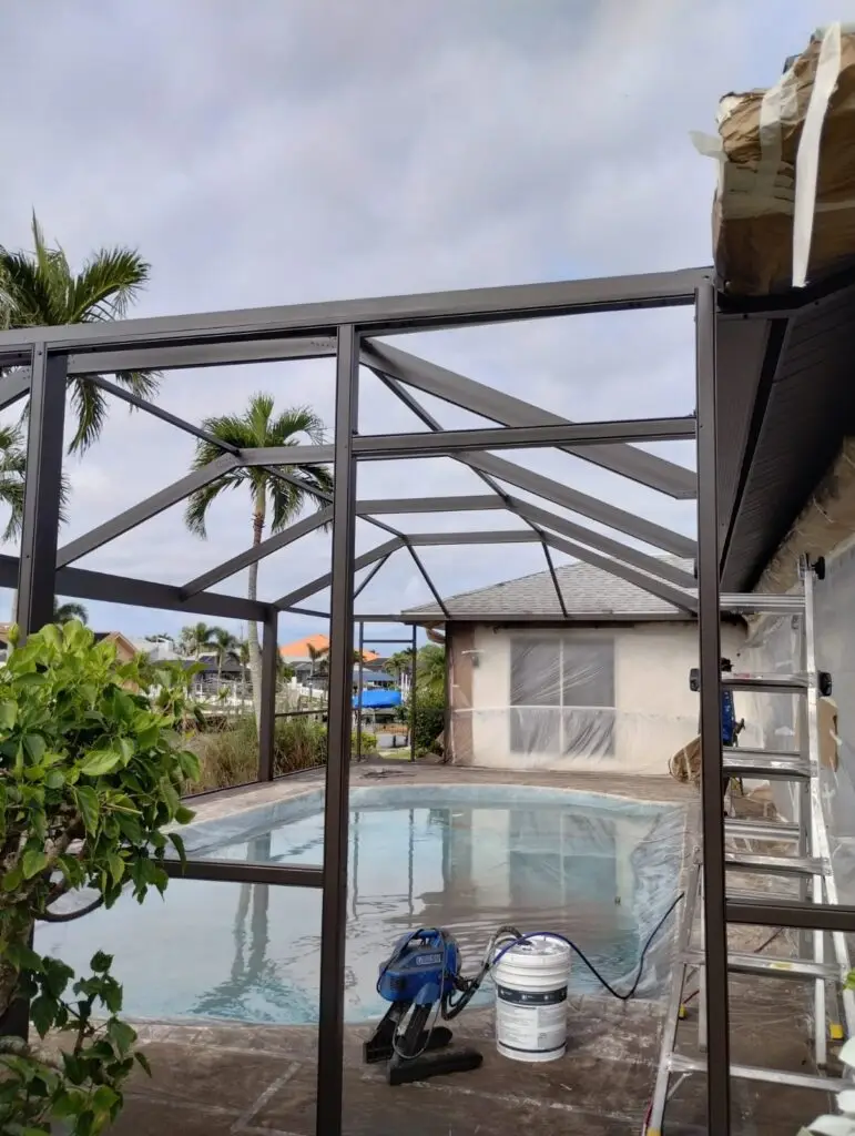 Bronze pool cage frame around the pool with the screen removed before painting