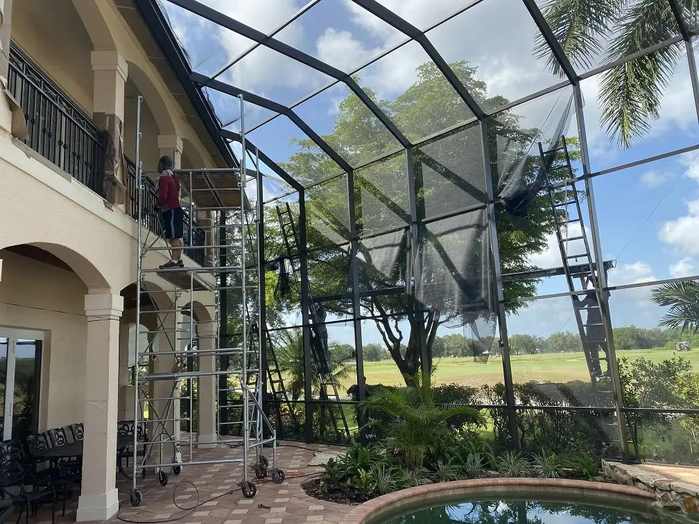 Pool cage rescreened with new screen, two-story lanai with a lake view