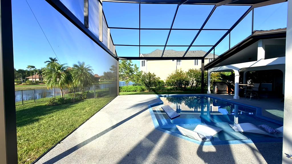 Freshly painted black pool cage enclosure over a pool and spa in Florida by ABC Pool Cage Painting